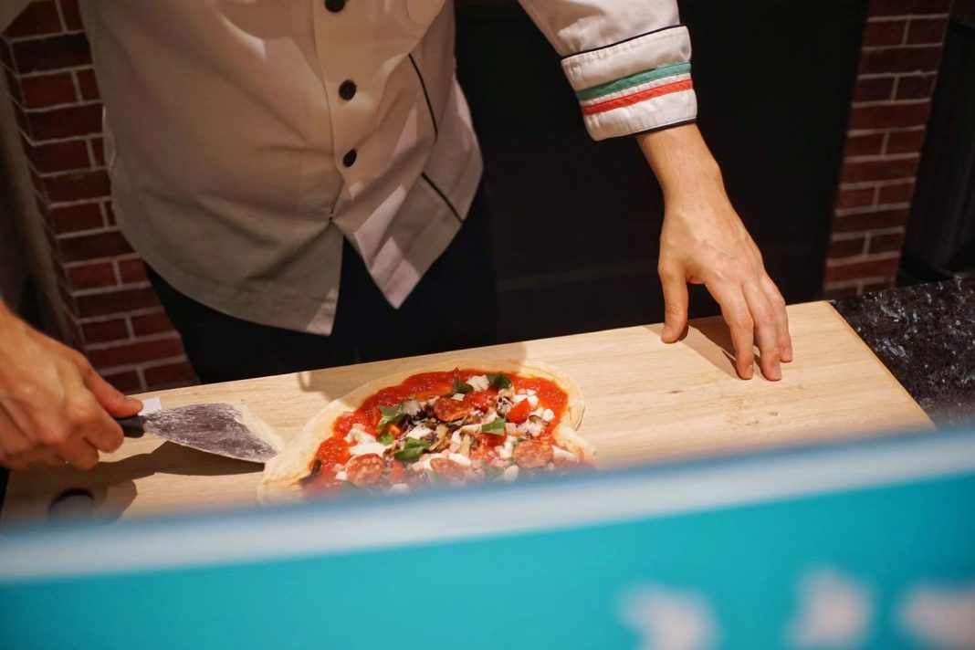 厨师在准备客人自制的披萨 | Chef preparing pizza made by guests in pizza making class